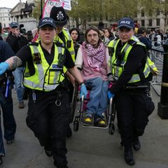 Polizisten tragen Demonstranten weg