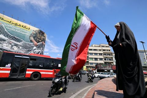Frau mit iranischer Flagge in Teheran