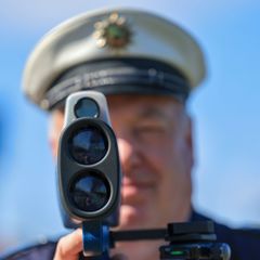 Vor einer Radarkontrolle der Polizei warnte ein Mann mit einem Plakat. (Symbolbild) Foto: Jan Woitas/dpa