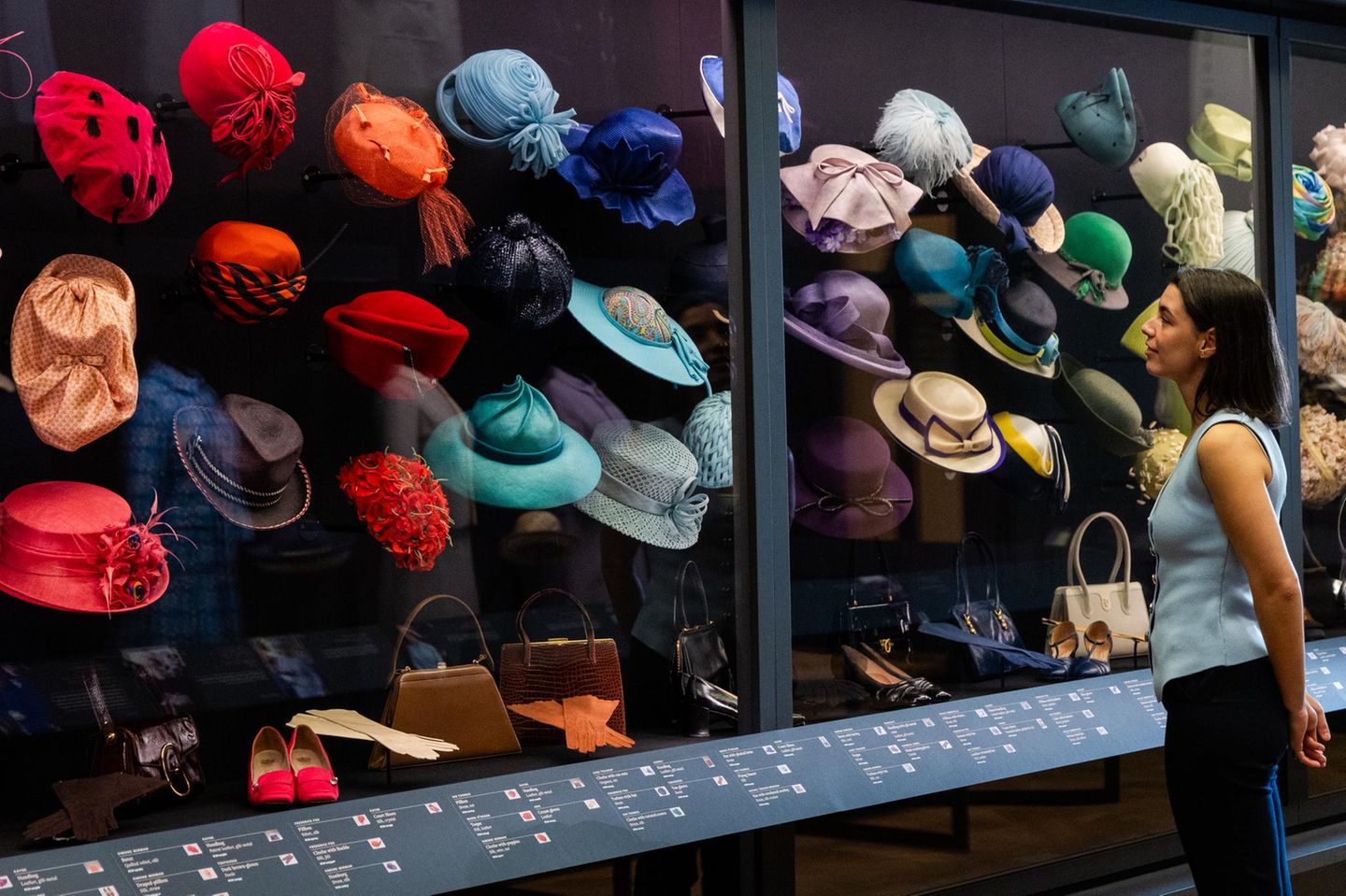 Hüte, nichts als Hüte! Unzählige Kopfbedeckungen trug die Queen zeit ihres langen Lebens. Stets in der Farbe ihres jeweiligen Kostüms, zu dem auch immer Handtasche und Schuhe (vorne) zu passen hatten. Mit dem roten Hut unten links …