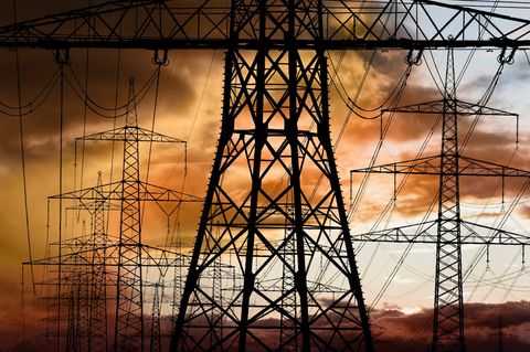 Strmmasten vor dramatischen dunkelrot eingefärbten Wolken als Symbolbild für Stromios Lieferschwierigkeiten