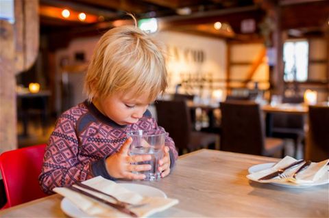 Kind mit Glas in einem Restaurant in Norwegen