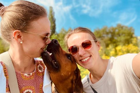 Alexandra und Katharina mit einem Hund in ihrer Mitte