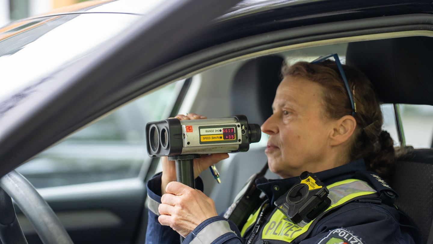 Eine Polizeibeamtin misst im Rahmen der sogenannten "Speedweek" auf einer Landstraße mit der Radarpistole die Geschwindigkeit de