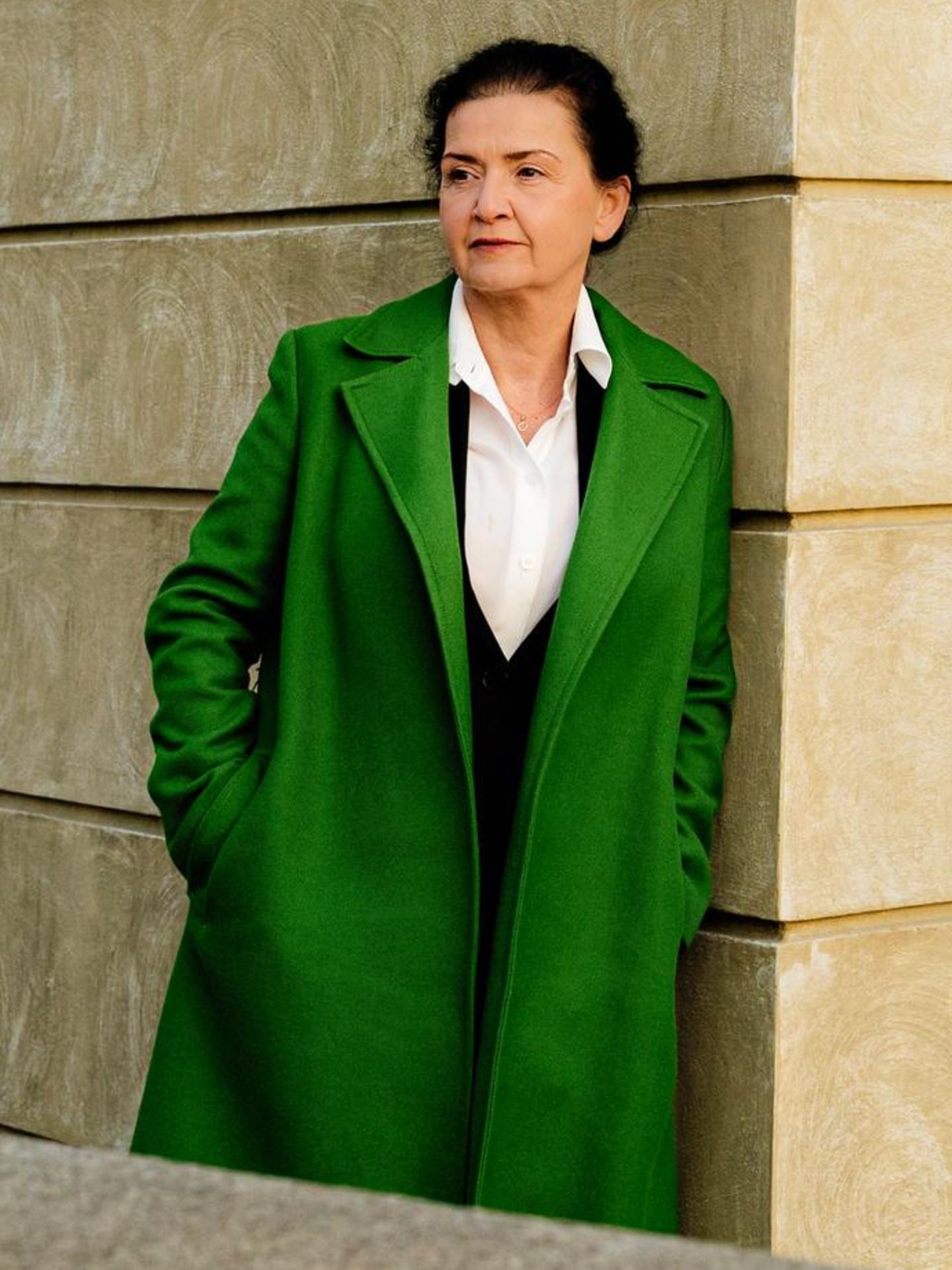 Andrea Seelich lehnt an einer beigen Betonwand
