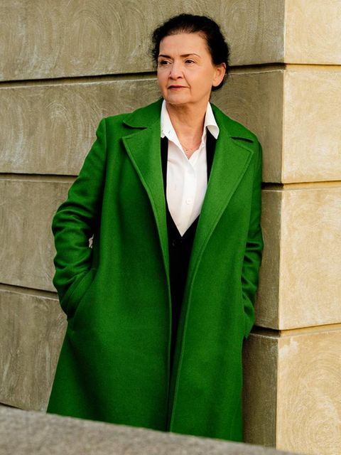 Andrea Seelich lehnt an einer beigen Betonwand