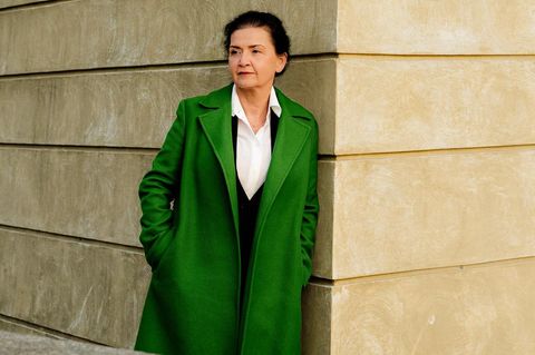 Andrea Seelich lehnt an einer beigen Betonwand