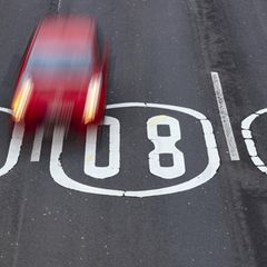 Symbolbild Tempolimit: 80 km/h Schild auf Straße gemalt