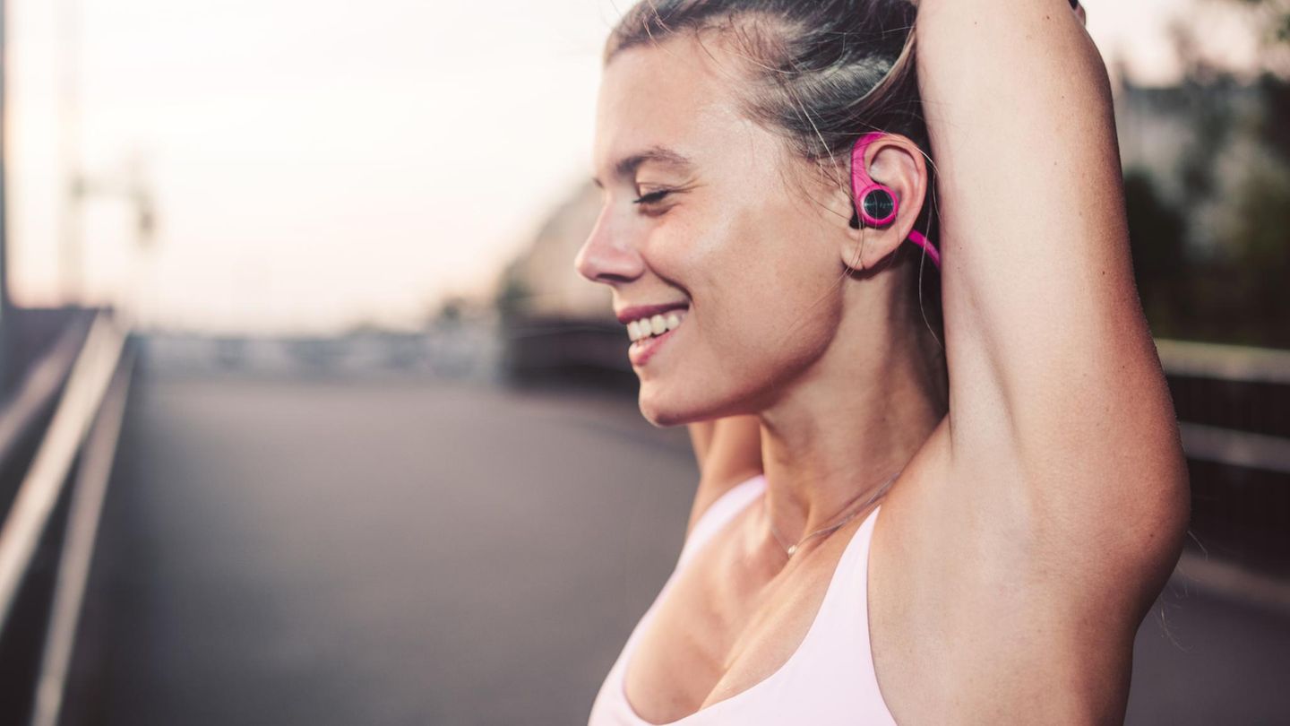 Happy woman doing stretching in the city.