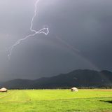 Schlehdorf, Deutschland. Der April macht – wettertechnisch zumindest – was er will. Das ist eine der bekanntesten Bauernregeln. Dieses Foto aus den bayerischen Voralpen scheint es zu bestätigen: dunkle Wolken, Sonnenschein, Blitz und Regenbogen.