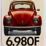 Ein Plakat für VW mit einem roten VW Käfer abgebildet