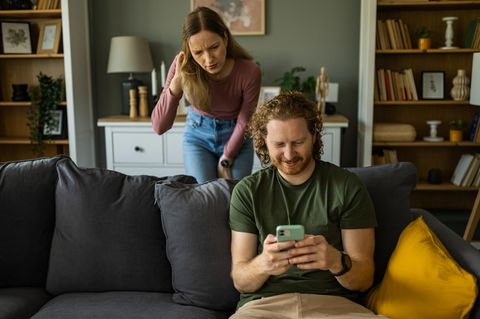 Eine Frau liest heimlich Nachrichten ihres Partners mit