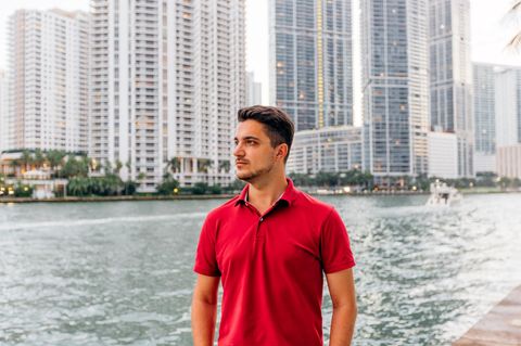 Portrait of a man wearing red polo shirt with skyscrapers of Miami Downtown in background