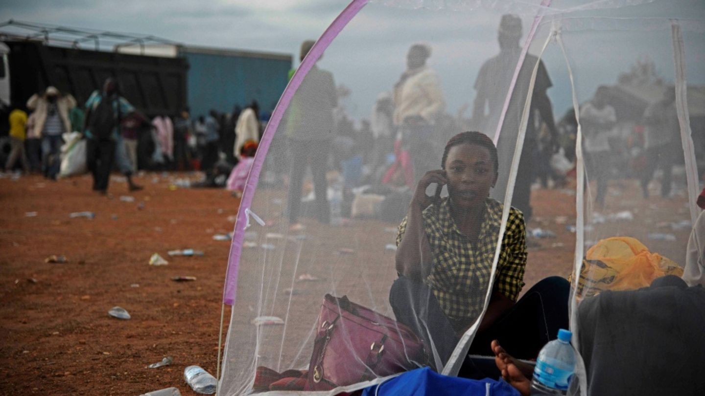 Smartphone-Nutzerin in provisorischem Lager in Uganda