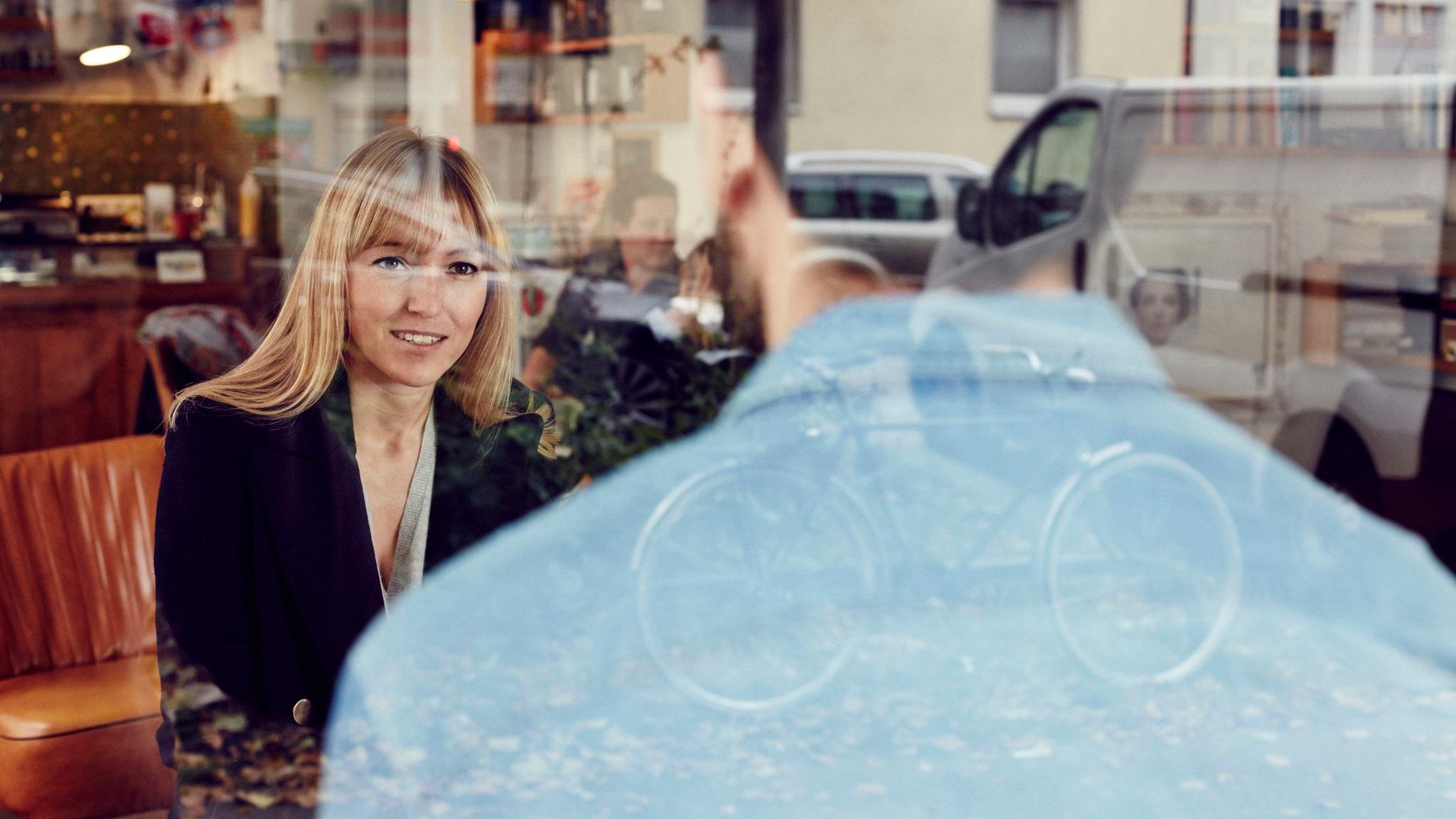 Ein Mann spricht mit mit einer Frau in einem Cafe