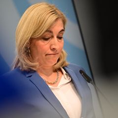 Gesundheitsministerin Nina Warken steht an einem Rednerpult und blickt nach unten