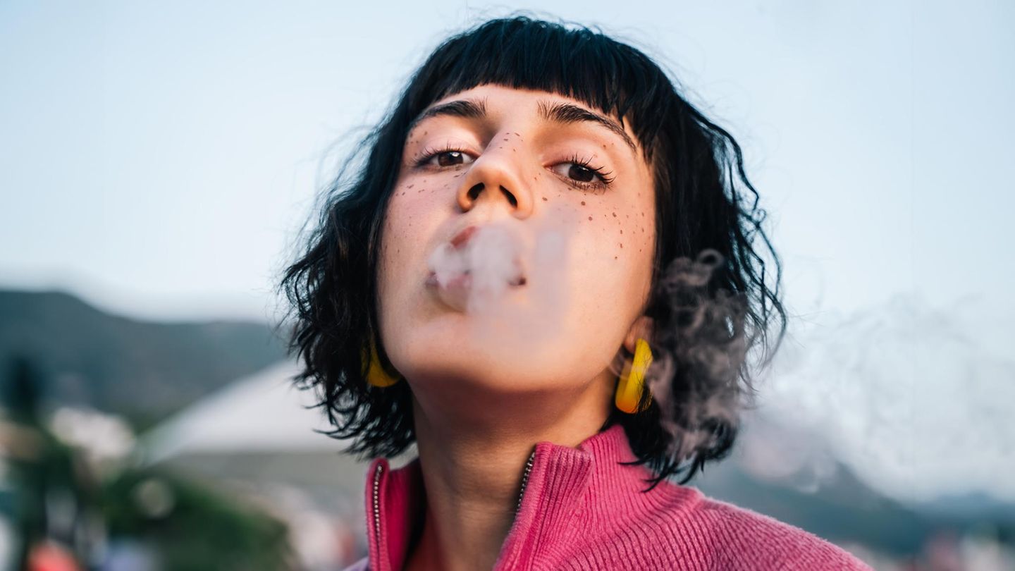 Thema Nikotin: Ein Frau mit Zigarettenrauch um den Mund