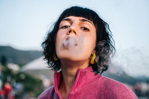 Thema Nikotin: Ein Frau mit Zigarettenrauch um den Mund