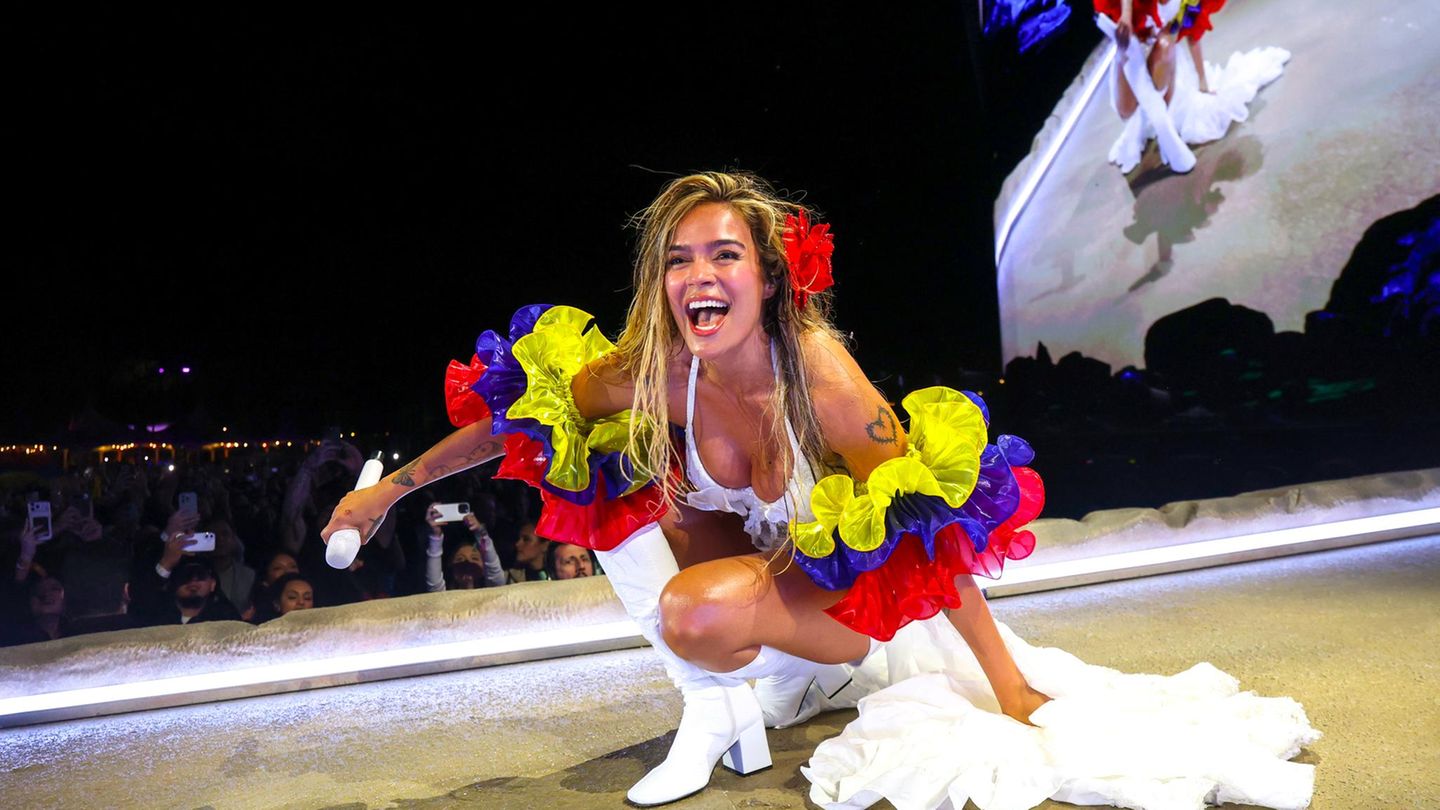 Karol G kniet beim Coachella-Festival auf der Bühne