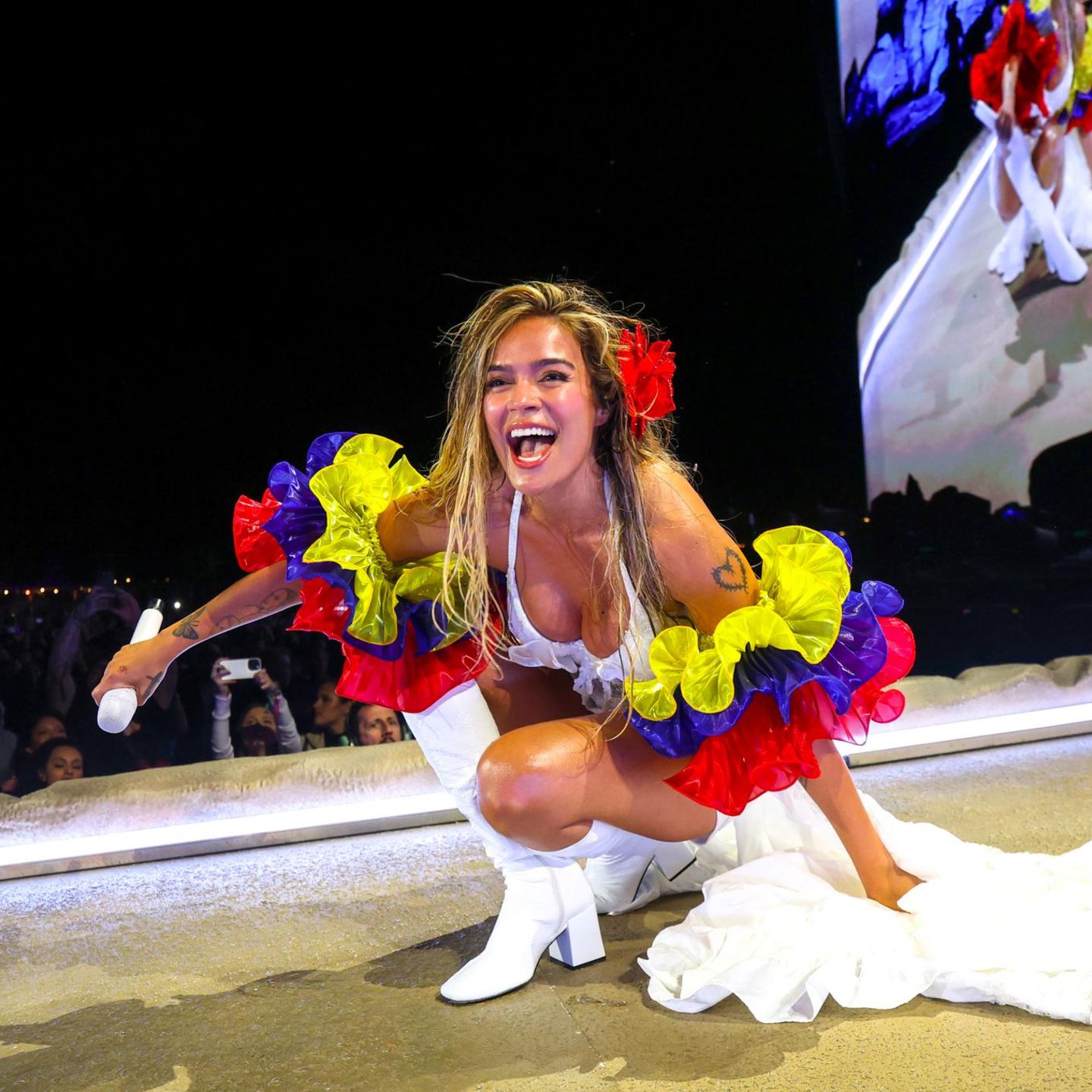 Karol G kniet beim Coachella-Festival auf der Bühne