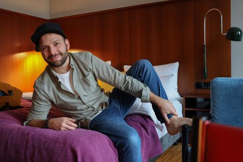 Callboy Ben liegt auf einem Hotelbett