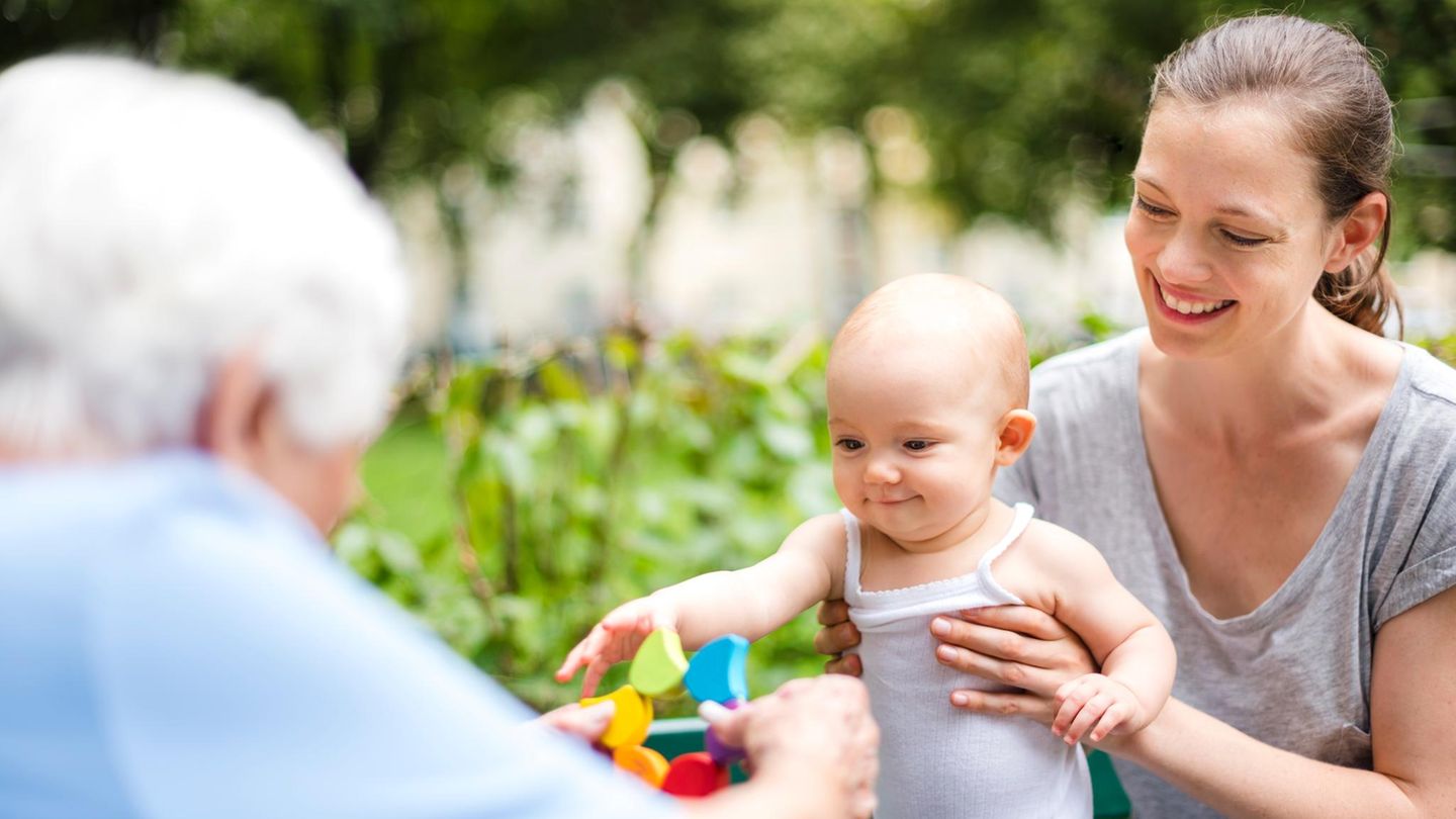 Eine Mutter hält ein glückliches Kind in den Händen