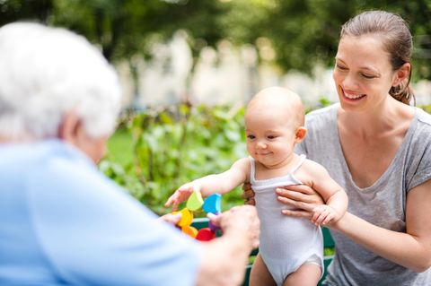 Eine Mutter hält ein glückliches Kind in den Händen