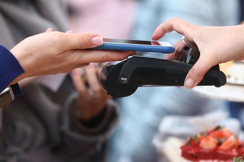 Ein iPhone zahlt an einem Bezahlterminal