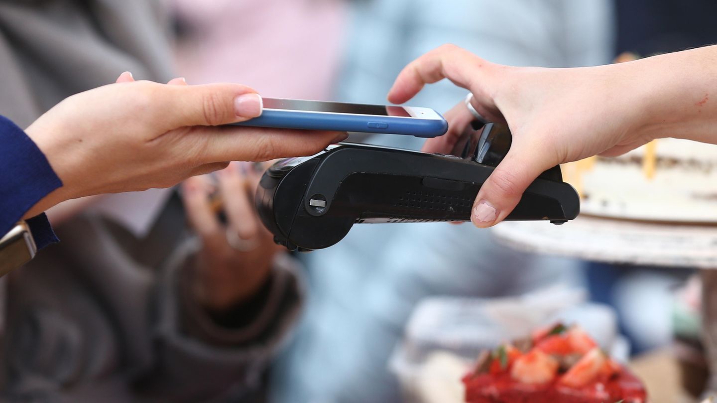 Ein iPhone zahlt an einem Bezahlterminal