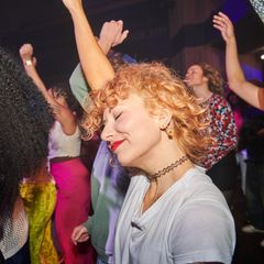 Eine Frau tanzt auf einer Party – Scheidungsparty Symbolbild