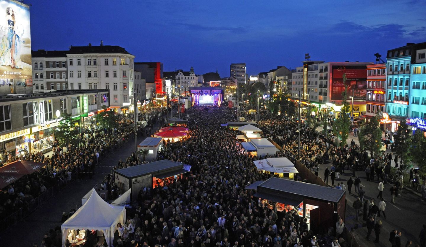 Viele Jahre diente der Spielbudenplatz an der Reeperbahn als deutsche Live-Bühne für den Eurovision Song Contest. Bis heute tobt hier jeden Sommer das Reeperbahn Festival. Auf der linken Seite sieht man den kleinen Broadway des Nordens, das Musical-Theater Operettenhaus, die Schmidts-Theater und das legendäre St. Pauli-Theater.