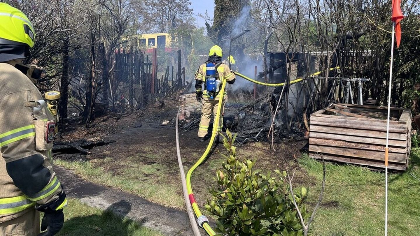 Einsatzkräfte der Feuerwehr löschen den Brand zweier Gartenhäuser. (Handout) Foto: ---/Berliner Feuerwehr/dpa