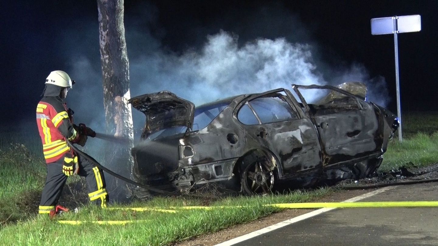 Feuerwehrleute löschen das Auto in der Nacht. Foto: Ulf Zurlutter/Nord-West-Media TV/dpa