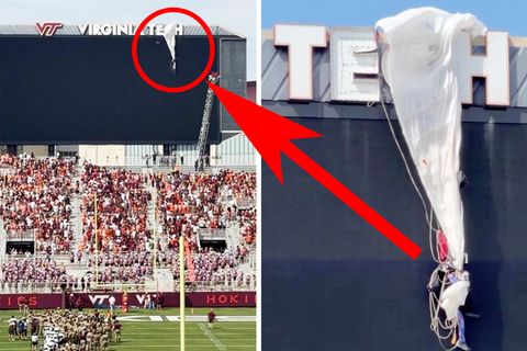 Fallschirmspringer kracht in Anzeigetafel eines Stadions