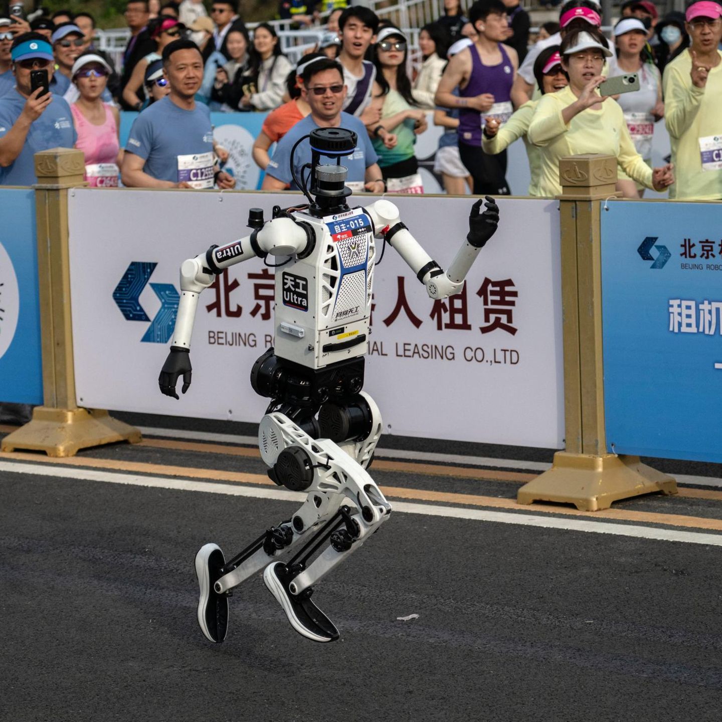 Peking, China. Beim Halbmarathon in der chinesischen Hauptstadt haben humanoide Roboter ihre menschliche Konkurrenz klar abgehängt. Der siegreiche Roboter der chinesischen Smartphone-Marke Honor legte die 21 Kilometer lange Strecke am Sonntag in 50 Minuten und 26 Sekunden zurück. Damit unterbot er den menschlichen Halbmarathon-Weltrekord, den der ugandische Läufer Jacob Kiplimo im März in Lissabon aufgestellt hatte, gleich um mehrere Minuten. Auch andere Roboter waren deutlich schneller als die Profisportler und liefen um mehr als zehn Minuten früher als die menschlichen Sieger im Ziel ein. Um Zusammenstöße zu vermeiden, traten die Maschinen und die 12.000 menschlichen Teilnehmer auf parallelen Bahnen an.