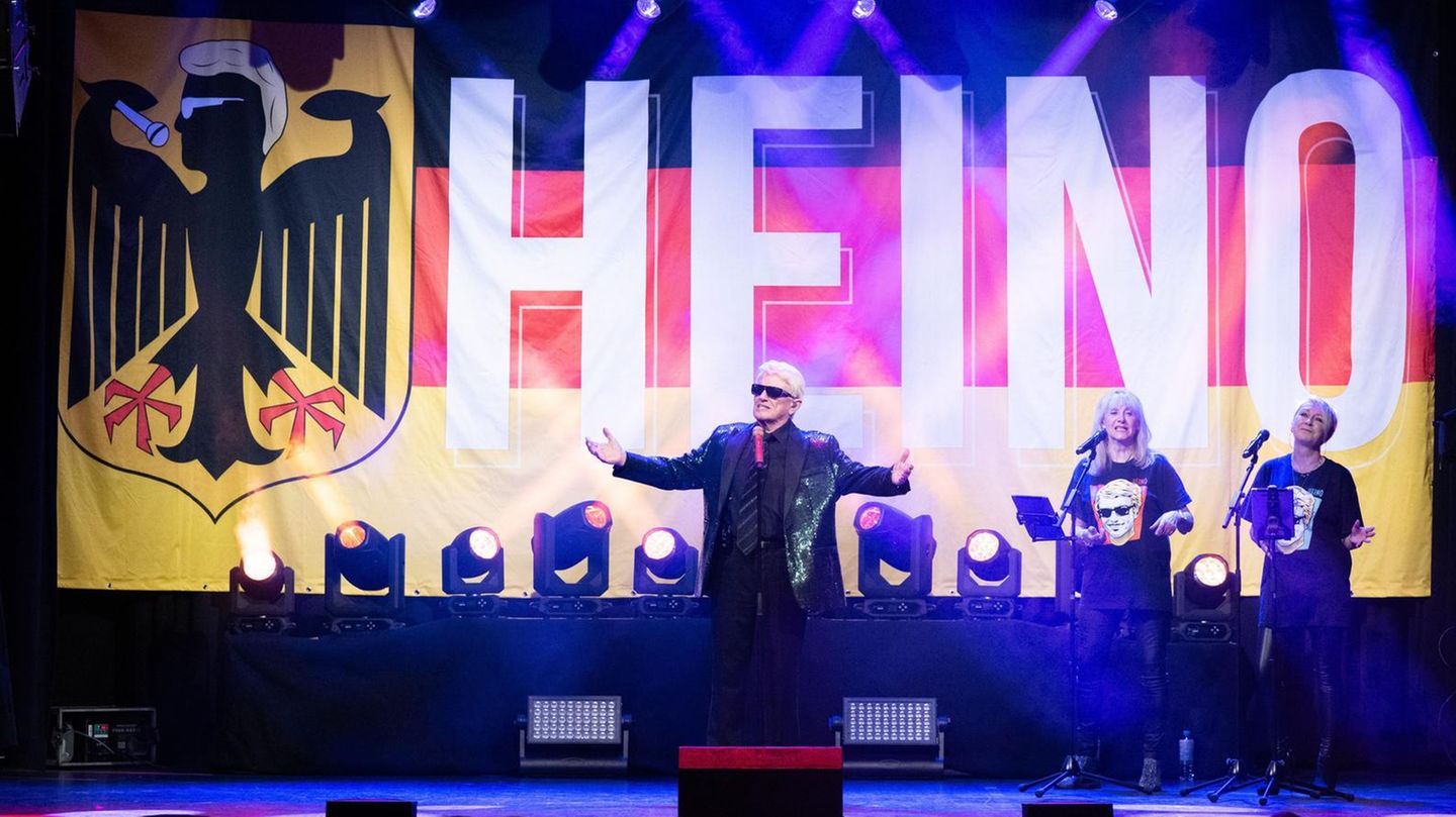 Der Sänger Heino vor einer Deutschlandflagge mit seinem Namen darauf