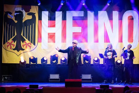 Der Sänger Heino vor einer Deutschlandflagge mit seinem Namen darauf