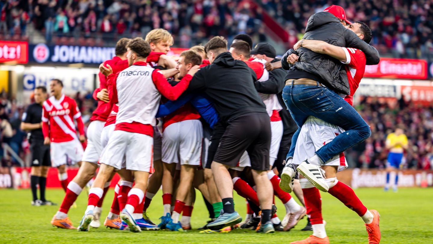 Cottbus im Jubel-Rausch: Trainer Claus-Dieter Wollitz springt seinem Dreifachtorschützen Tolcay Cigerci (r) in die Arme. Foto: F