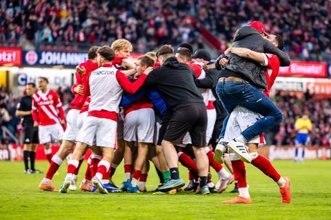 Cottbus im Jubel-Rausch: Trainer Claus-Dieter Wollitz springt seinem Dreifachtorschützen Tolcay Cigerci (r) in die Arme. Foto: F