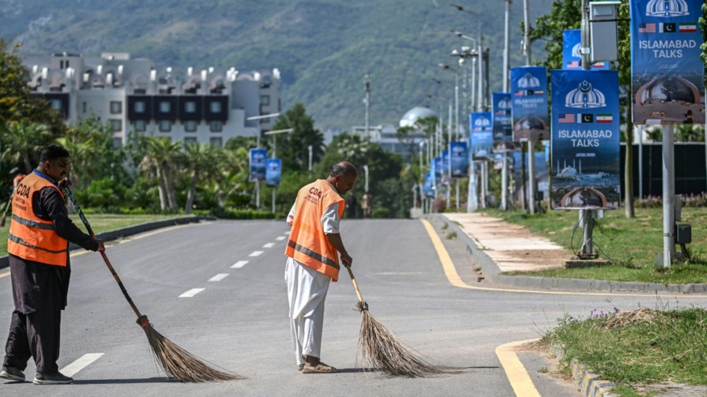 Reinungskräfte säubern eine Straße in Islamabad