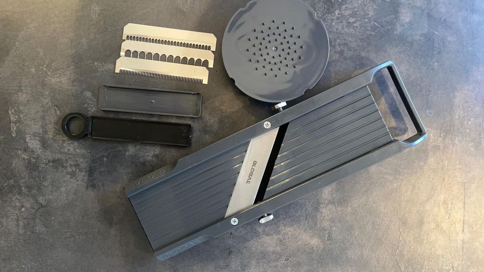 Drei Julienneklingen, ein Restehalter und eine Schachtel für die Klingen liegen dem Global-Hobel bei