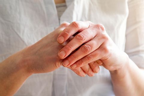 Handekzem: Eine Person reibt sich die Hände, die Haut ist gerötet