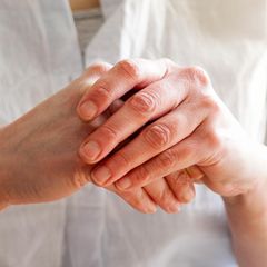 Handekzem: Eine Person reibt sich die Hände, die Haut ist gerötet