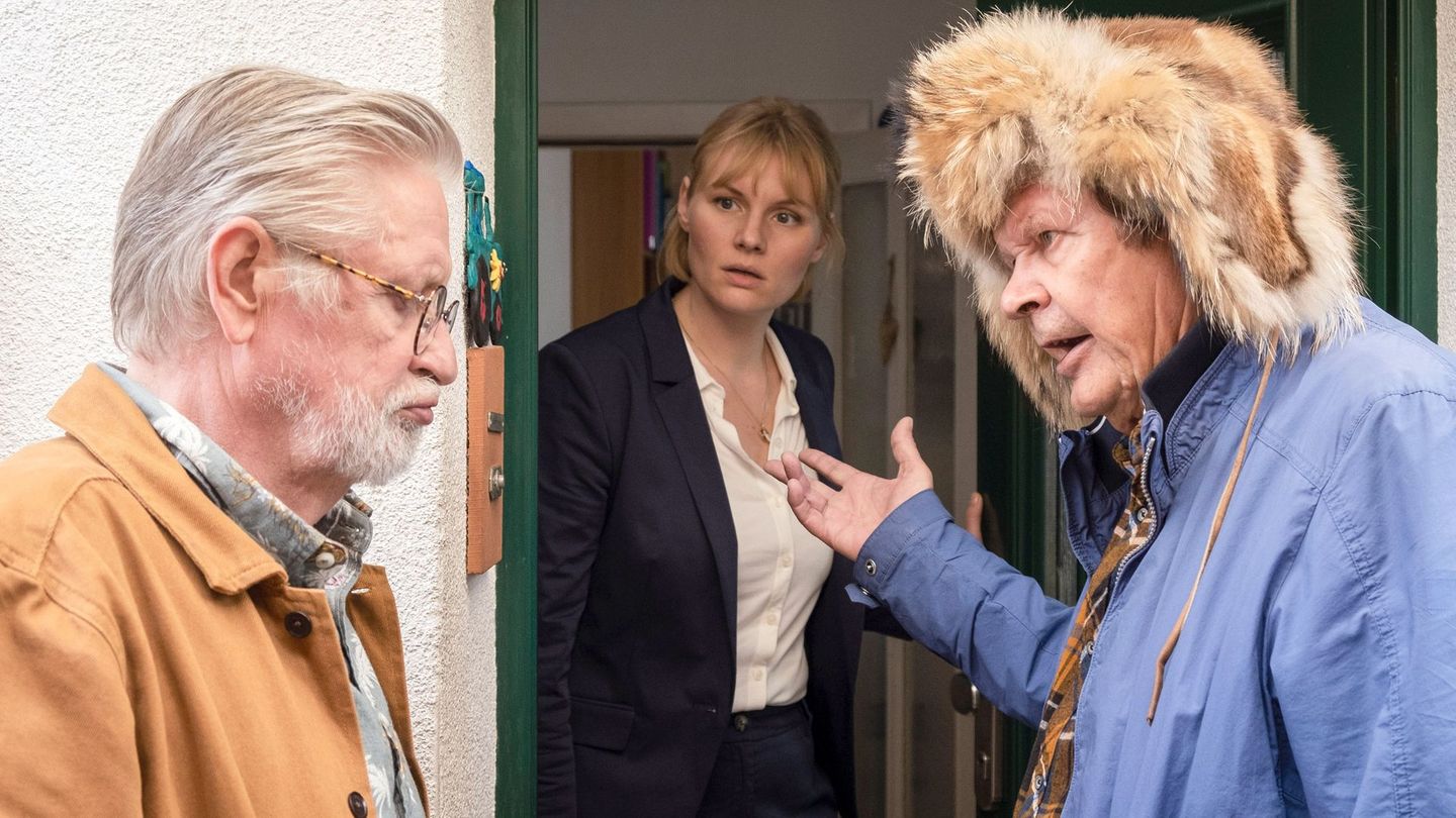 Der alte Griesgram (Heikki Kinnunen, rechts) drängt seinen Bruder Tarmo (Kari Väänänen), auf dem Weg zu dem roten Escort einen Zwischenstopp bei Tarmos entfremdeter Tochter Maria (Rosalie Thomass) einzulegen.