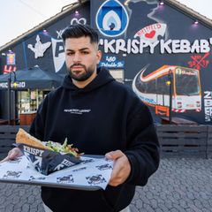 Dönerketten-Chef Sergen Kolcu vor einer seiner Filialen in Bielefeld. Foto: Friso Gentsch/dpa