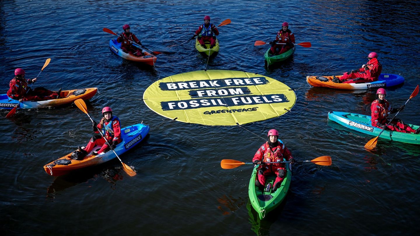 Greenpeace fordert bei einer Aktion am Veranstaltungsort die Abkehr von fossilen Energien. Foto: Kay Nietfeld/dpa
