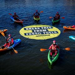 Greenpeace fordert bei einer Aktion am Veranstaltungsort die Abkehr von fossilen Energien. Foto: Kay Nietfeld/dpa