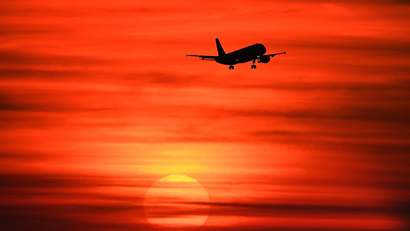 Ein Flugzeug im Sonnenuntergang – viele Fluglinien streichen schon Flüge