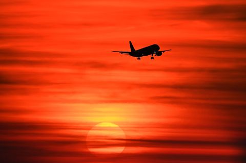 Ein Flugzeug im Sonnenuntergang – viele Fluglinien streichen schon Flüge