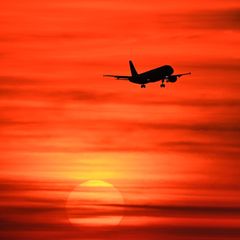 Ein Flugzeug im Sonnenuntergang – viele Fluglinien streichen schon Flüge